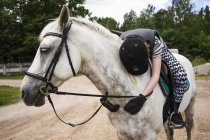 Junges Mädchen umarmt Pferd, Fokus auf Vordergrund — Stockfoto