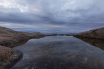 Rock pool under overcast sky in north of Sweden — Stock Photo