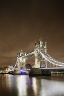 Illuminated Tower Bridge over Thames River in London at night — Stock Photo