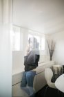 Жінка розмовляє на смартфоні за вікном — стокове фото