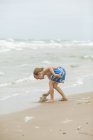 Boy building sandcastle on beach in Denmark — Stock Photo