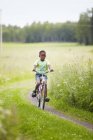 Menino de ciclismo em campo, foco seletivo — Fotografia de Stock