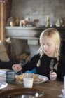 Mädchen isst Pfannkuchen zum Frühstück, Fokus auf Vordergrund — Stockfoto