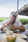 Homem adulto médio comendo melancia, foco seletivo — Fotografia de Stock
