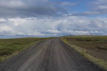 Schotterpiste unter Himmel mit Wolken in Island — Stockfoto
