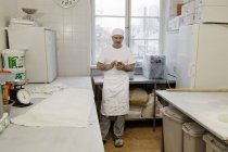 Шеф-повар держит смартфон на кухне — стоковое фото
