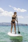 Woman paddle boarding, focus on foreground — Stock Photo