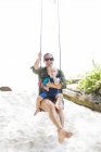 Woman holding son on swing at beach, focus on foreground — Stock Photo