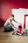 Femme versant de la peinture dans un bac à peinture — Photo de stock