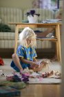 Girl playing with dolls at living room — Stock Photo