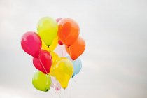 Pacote de balões contra céu nublado, foco em primeiro plano — Fotografia de Stock