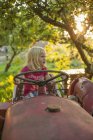 Mädchen auf Traktor schaut weg, Linsenschlag — Stockfoto