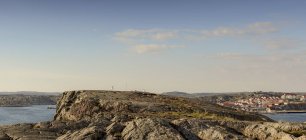 Vista de la formación rocosa en la costa oeste sueca y la ciudad en el fondo - foto de stock