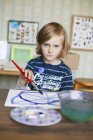 Portrait of girl with paint brush, selective focus — Stock Photo
