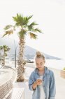 Junge Frau blickt aufs Smartphone, konzentriert sich auf den Vordergrund — Stockfoto