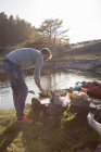 Hombre acampando en la orilla del río, costa sueca oeste - foto de stock