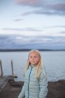 Portrait de fille aux cheveux blonds devant le lac — Photo de stock