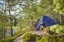 Ragazzo e donna campeggio nella foresta, attenzione selettiva — Foto stock