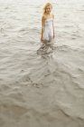 Chica de pie junto al lago, enfoque diferencial - foto de stock