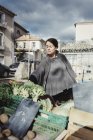 Молода жінка вибирає овочі на ринку — стокове фото
