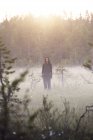 Mid adult woman standing in misty field — Stock Photo