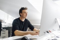 Чоловік, який друкує за комп'ютером, вибірковий фокус — стокове фото