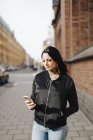Mulher usando telefone inteligente na rua, foco em primeiro plano — Fotografia de Stock