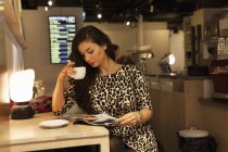 Jovem mulher na estação de trem beber café e ler revista — Fotografia de Stock