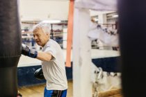 Тренировка пожилых людей с боксерской грушей — стоковое фото