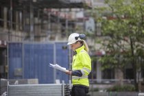 Ouvrier de la construction regardant les plans, mise au point sélective — Photo de stock