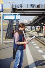 Чоловік дивиться на карту на залізничному вокзалі в Берліні — стокове фото