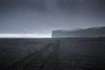 Camino de grava en Islandia contra nubes de tormenta - foto de stock