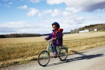 Menina de ciclismo no campo, foco seletivo — Fotografia de Stock