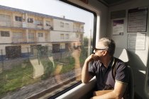 Человек в поезде смотрит в окно, избирательный фокус — стоковое фото