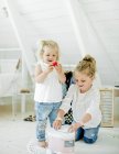 Schwestern spielen mit Spielzeug-LKW im Schlafzimmer — Stockfoto