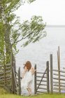 Вид ззаду дівчини, що йде до озера, вибірковий фокус — стокове фото