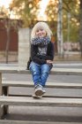 Girl sitting on bench, selective focus — Stock Photo