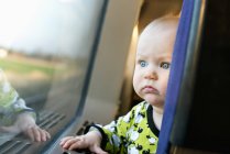 Bébé fille regardant par la fenêtre du train — Photo de stock