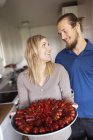 Man and woman holding crayfish on plate, focus on foreground — Stock Photo