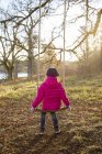 Rear view of girl in pink jacket looking at river — Stock Photo
