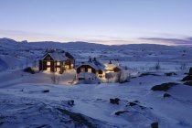 Освещенные здания в снегу зимой — стоковое фото