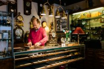 Чоловік за лічильником в антикварному магазині — стокове фото