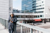 Hombre en el teléfono inteligente de la calle en Estocolmo, Suecia - foto de stock