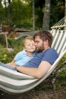 Father and son relaxing in hammock, focus on foreground — Stock Photo