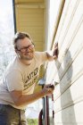 Ritratto di proprietario di casa riparare muro di casa — Foto stock