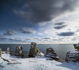 Formações rochosas na neve na costa, Escandinávia — Fotografia de Stock