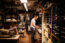 Homem maduro focado trabalhando em oficina de couro — Fotografia de Stock