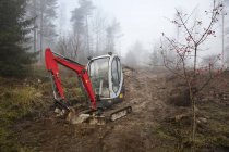 Bulldozer in foggy forest, northern europe — Stock Photo