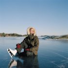 Mitte erwachsene Frau sitzt auf zugefrorenem See — Stockfoto