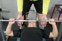 Levantamento de peso jovem mulher com barra no ginásio, foco seletivo — Fotografia de Stock